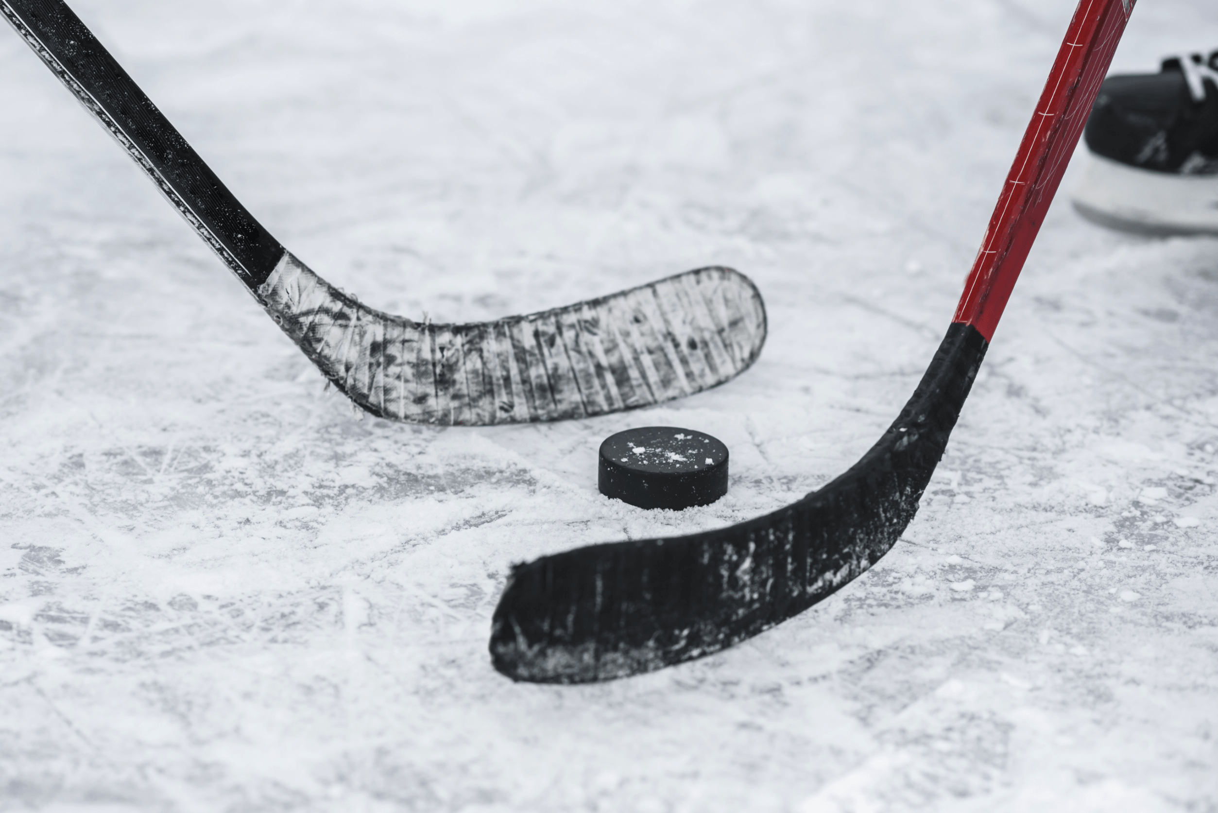 Hockey sticks and a puck on the ice